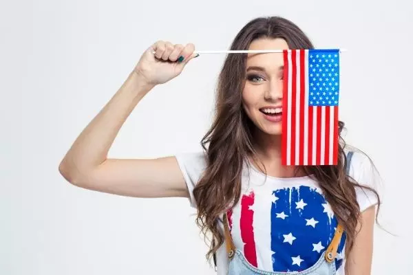 ¿Cómo es la vida en los Estados Unidos? Mujer joven con bandera de Estados Unidos